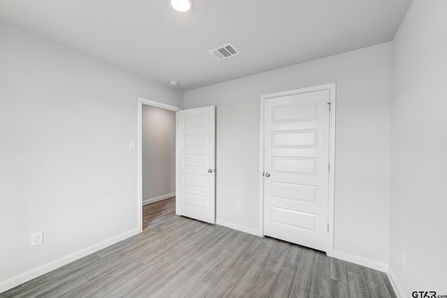 unfurnished bedroom with a closet and light wood-type flooring