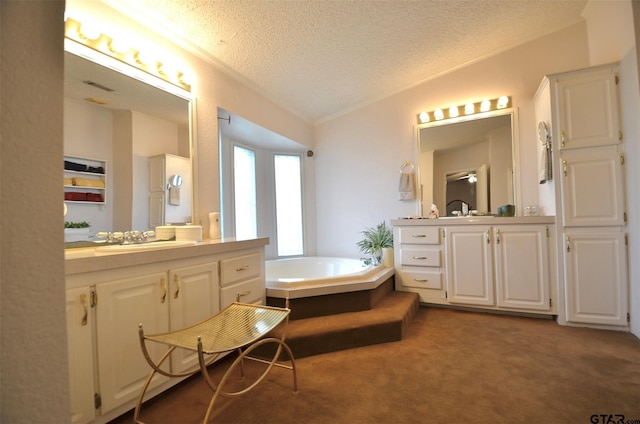 116 Piney Pt, Murchison, TX 75778 - bathroom featuring two vanities, a textured ceiling, a bath, and ornamental molding