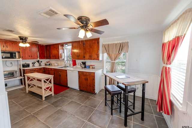 kitchen with light countertops, ceiling fan, dishwasher, visible vents, and black microwave