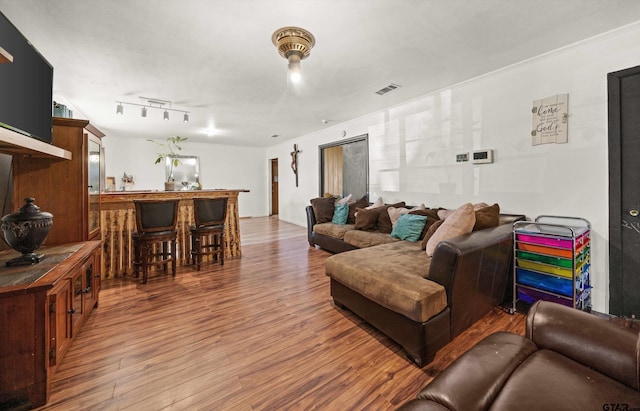 living room with indoor bar and hardwood / wood-style flooring