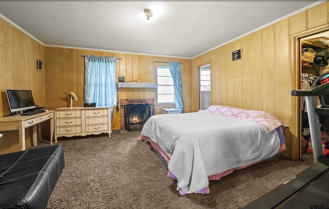 bedroom featuring dark colored carpet, ornamental molding, and wooden walls