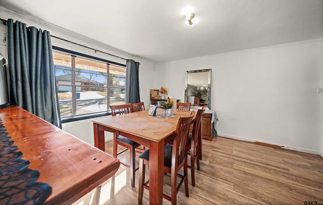 dining room with hardwood / wood-style flooring and ornamental molding