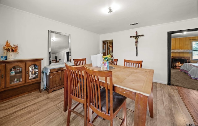 dining area featuring crown molding and light hardwood / wood-style flooring