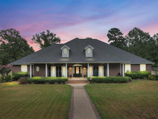 view of front of property with a yard and covered porch