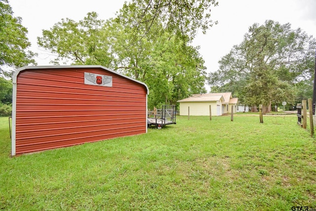 view of yard featuring fence and an outbuilding