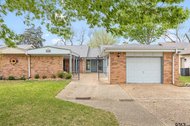 single story home with brick siding, central AC unit, concrete driveway, and a front yard