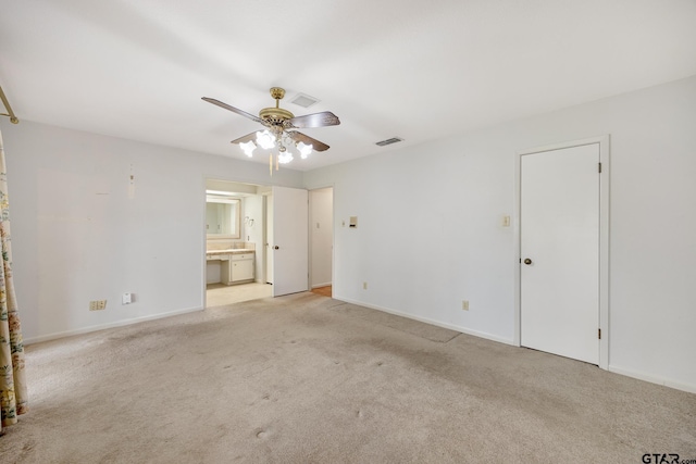 spare room featuring a ceiling fan, light carpet, baseboards, and visible vents