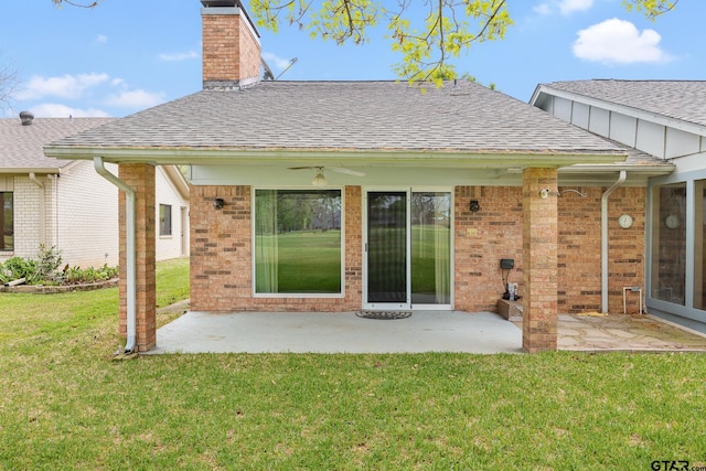 back of house featuring a lawn, a patio area, and roof with shingles