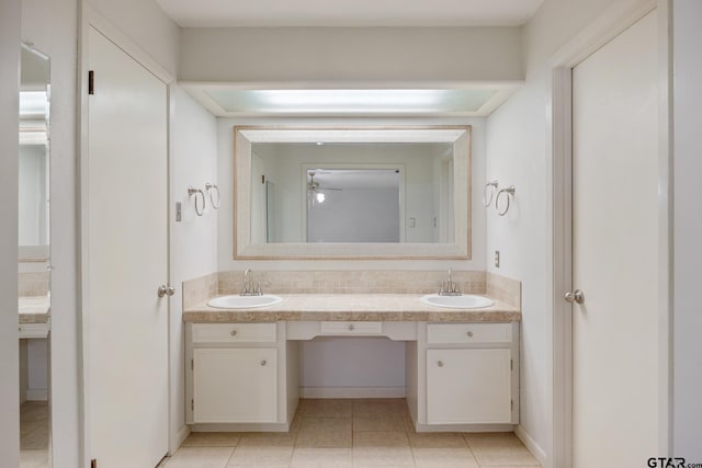 full bath featuring double vanity, baseboards, a sink, and tile patterned floors
