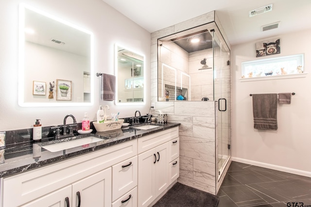 20855 Bay Shore Dr, Flint, TX 75762 - bathroom featuring marble finish floors, double vanity, a shower stall, and baseboards