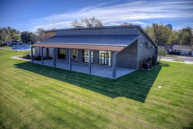 rear view of property with a yard and a patio area