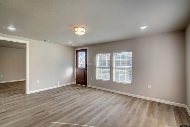 entryway featuring a textured ceiling and light hardwood / wood-style flooring