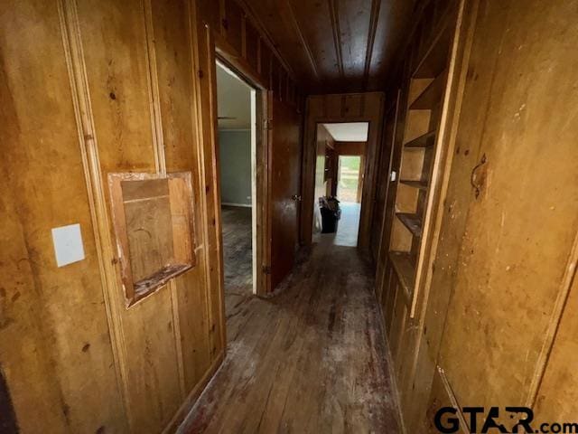 corridor with wooden ceiling, dark hardwood / wood-style floors, and wooden walls