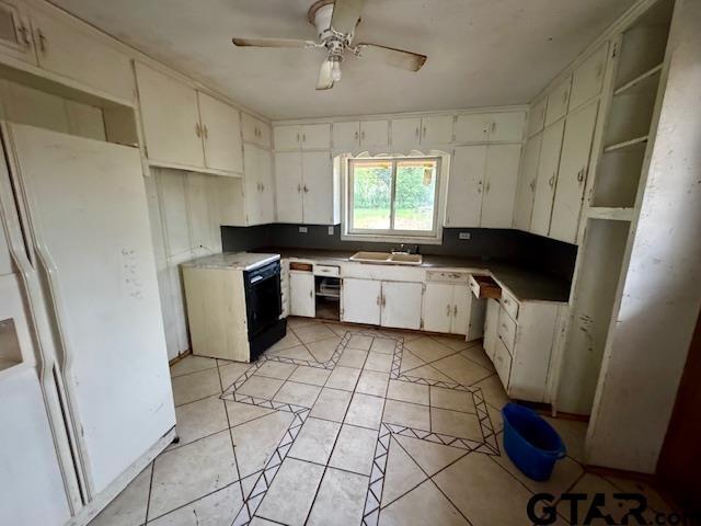 kitchen with ceiling fan, white cabinetry, white fridge with ice dispenser, and sink