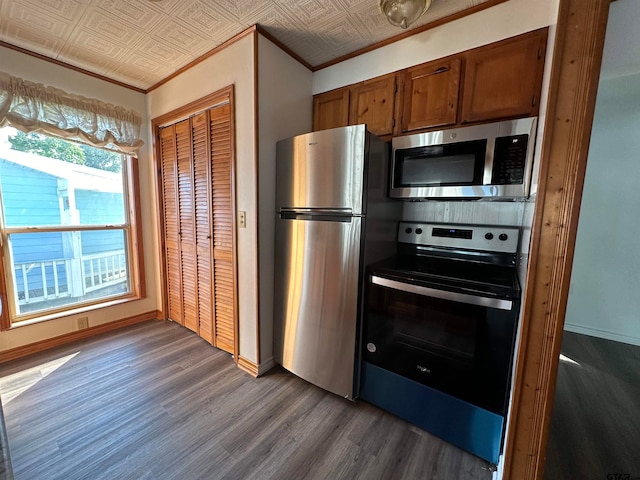 kitchen with ornamental molding, appliances with stainless steel finishes, and dark hardwood / wood-style floors