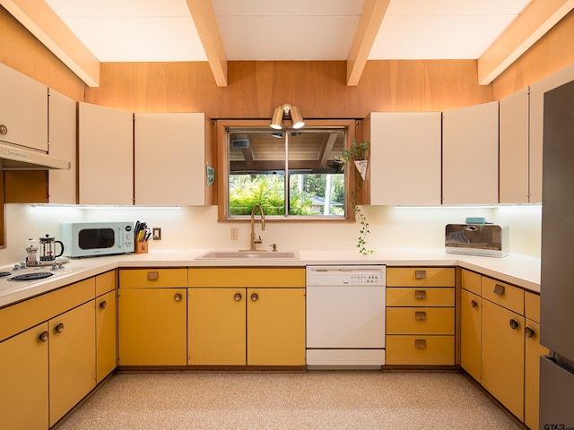 kitchen with beamed ceiling, white appliances, and sink