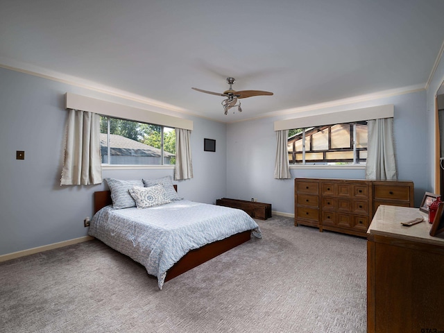 bedroom with ornamental molding, light colored carpet, and ceiling fan