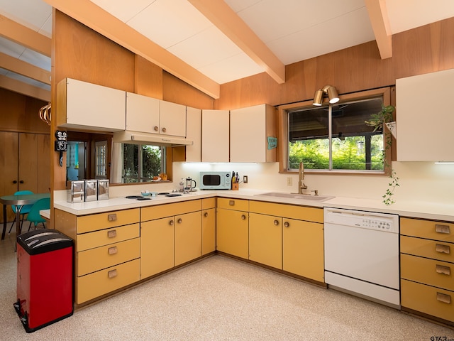 kitchen with light colored carpet, vaulted ceiling with beams, wooden walls, sink, and white appliances