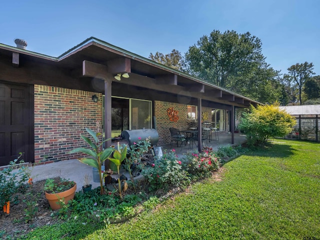 back of house featuring a lawn and a patio