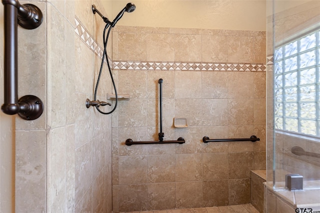 bathroom featuring a wealth of natural light and a tile shower