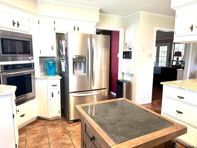 kitchen featuring white cabinetry, appliances with stainless steel finishes, a textured ceiling, and crown molding