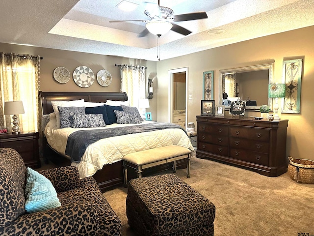 bedroom featuring light colored carpet, a textured ceiling, and ceiling fan