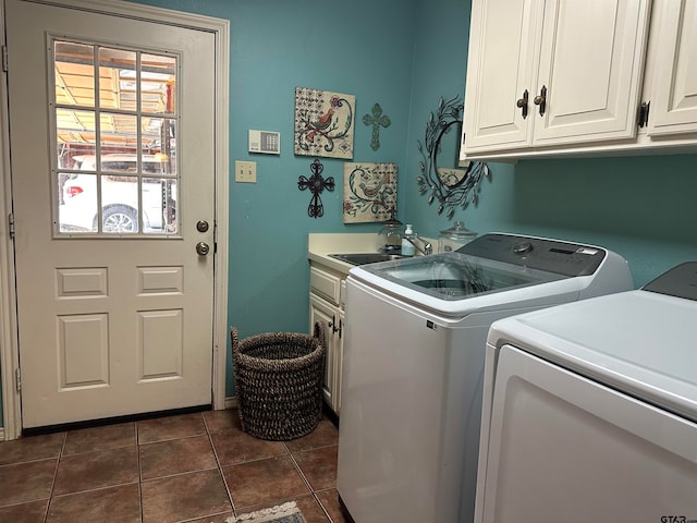 washroom with dark tile patterned floors, cabinets, sink, and separate washer and dryer