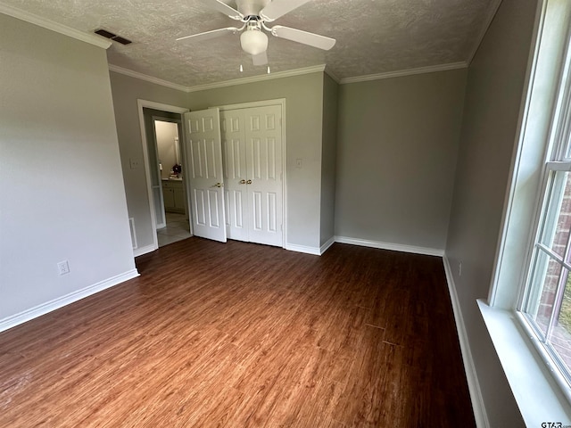 unfurnished bedroom with ceiling fan, wood-type flooring, a textured ceiling, and crown molding