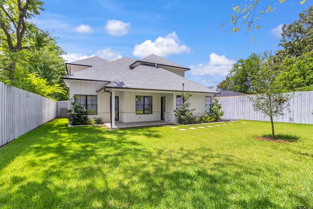 rear view of property featuring a lawn and a patio