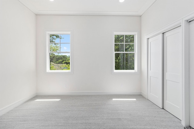 unfurnished bedroom featuring light carpet, a closet, and ornamental molding