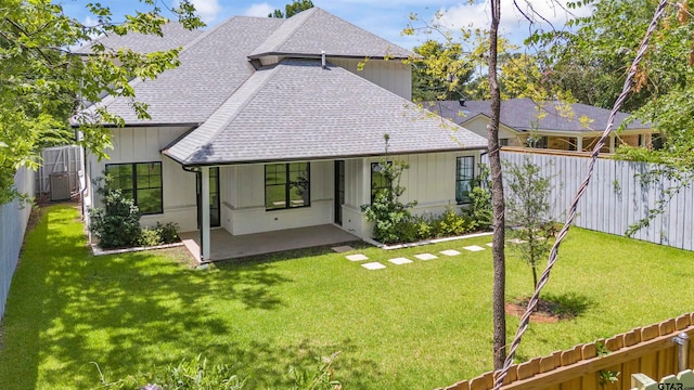 rear view of house featuring a lawn and a patio