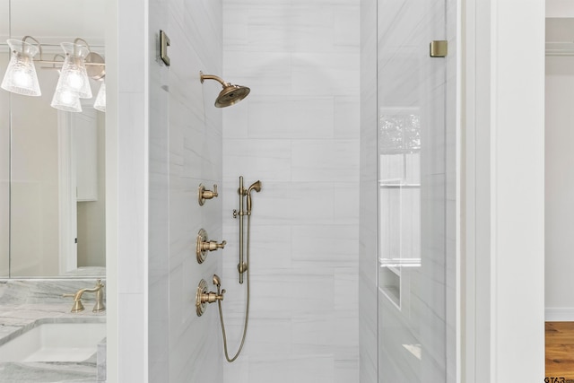 bathroom featuring a tile shower, vanity, and hardwood / wood-style flooring