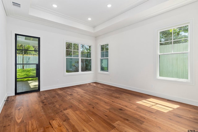 spare room with hardwood / wood-style floors, a healthy amount of sunlight, and ornamental molding