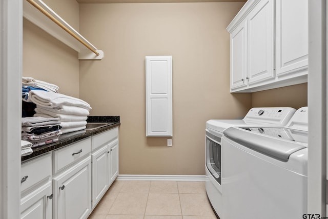 laundry room with cabinets, washer and dryer, and light tile patterned flooring