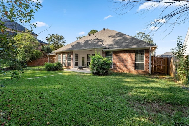 rear view of property featuring a lawn and a patio