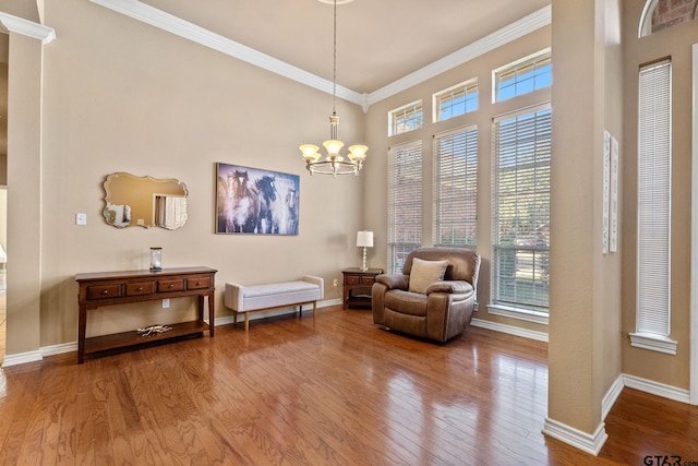 sitting room featuring ornamental molding, hardwood / wood-style floors, and a chandelier