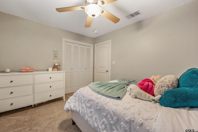 bedroom with ceiling fan, light carpet, and a closet