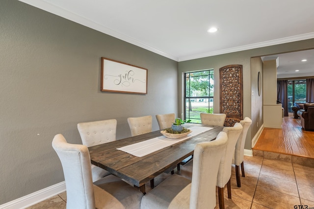 dining space with light hardwood / wood-style flooring and crown molding