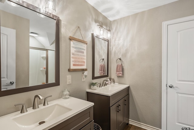 bathroom with a shower with shower door and vanity