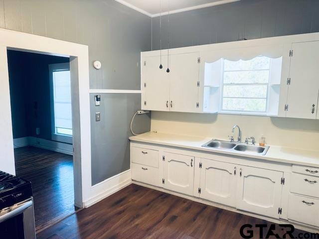 kitchen featuring stainless steel range with gas cooktop, dark hardwood / wood-style flooring, ornamental molding, white cabinets, and sink