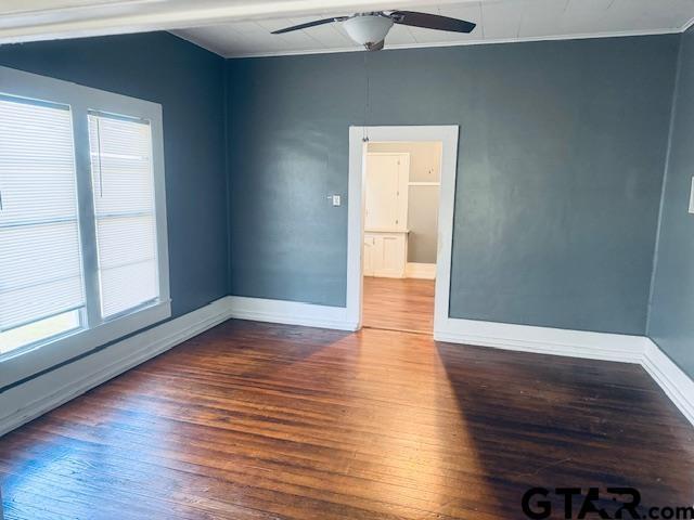 spare room featuring ceiling fan and dark wood-type flooring