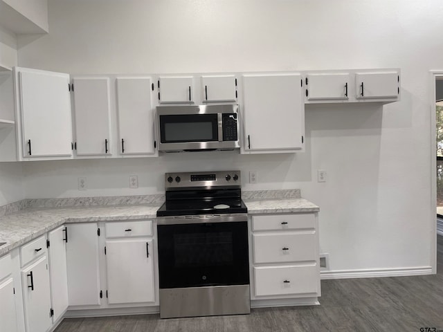 kitchen with white cabinets, stainless steel appliances, and dark hardwood / wood-style flooring