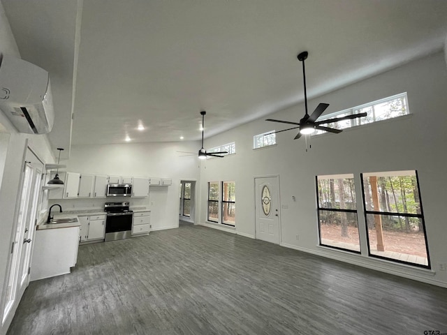 unfurnished living room with high vaulted ceiling, ceiling fan, dark hardwood / wood-style floors, and sink