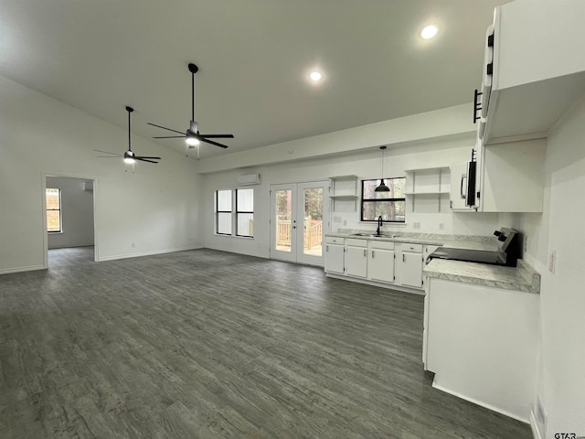 kitchen featuring french doors, black range oven, sink, dark hardwood / wood-style floors, and white cabinetry