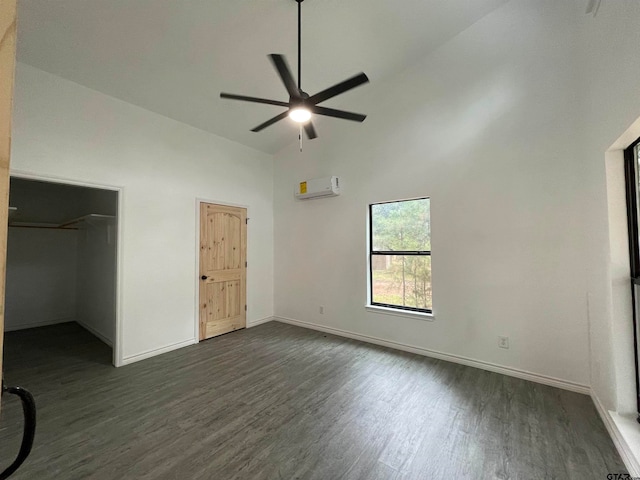 unfurnished bedroom with dark hardwood / wood-style flooring, high vaulted ceiling, ceiling fan, a spacious closet, and a wall mounted air conditioner