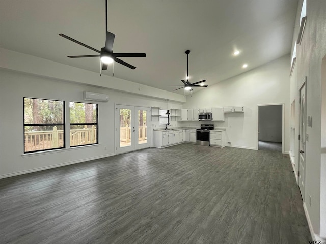 unfurnished living room with ceiling fan, dark hardwood / wood-style floors, sink, and high vaulted ceiling