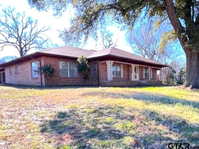 single story home featuring a front lawn