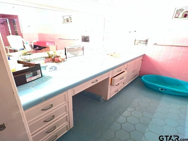 bathroom with vanity, tile patterned floors, and tile walls