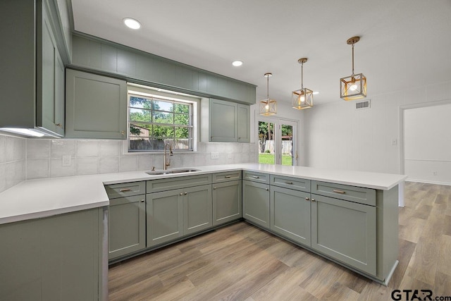 199 Plum St, Rusk, TX 75785 - kitchen with a peninsula, a sink, backsplash, light countertops, and light wood-style flooring