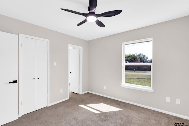 unfurnished bedroom with ceiling fan, carpet floors, and a closet